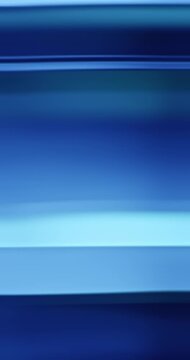 Radiant blue lights illuminate the brilliance of moving reflective glass creating a gradient of soft blues for a calm, relaxing aura. Smooth dreamy blue lighting abstract background or wallpaper Loop