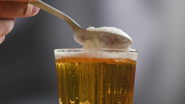 Fresh Spanish small beer served in a small glass with creamy foam at a traditional bar. Classic draft lager, authentic pub atmosphere, close-up food and drink