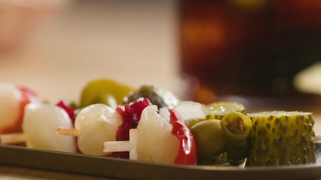 Gilda pintxo, traditional Spanish tapas with hot green pepper, anchovy, olives and pickled vegetables, served with vermouth