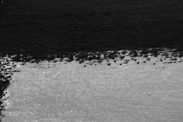 Black and white paint strokes on a white surface. Texture and paint colors, rough surface