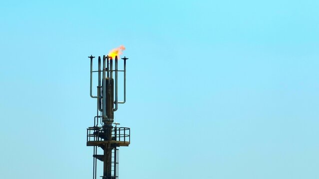 Aerial drone view of an oil refinery flare stack releasing burning gas, highlighting industrial energy production, petroleum processing, and environmental impact in the modern energy sector. 4k.

