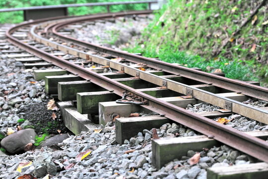 Miniature railway tracks curving through green outdoor landscape