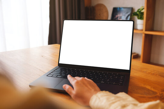 Mockup image of a woman working on laptop computer with blank screen at home