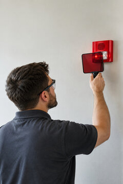 Fire alarm specialist testing a visual strobe