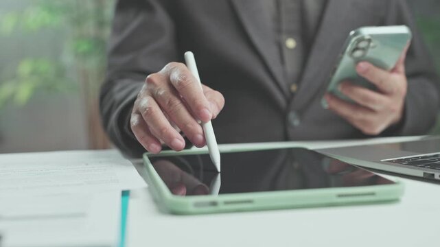 Executive conducts digital analysis on tablet while business analysis informs daily investment choices, ensuring sound corporate investment.