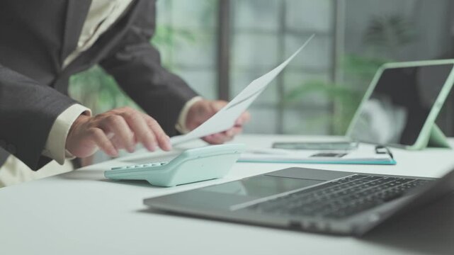 Accountant performs financial audit tasks on desk papers, ensuring thorough financial planning as corporate audit procedures review commercial budget balance.
