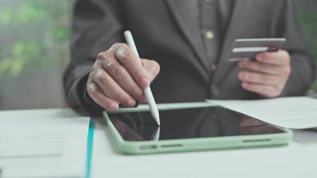Executive manages payment authorization on digital equipment, ensuring secure payment verification during online transaction processing with credit card.