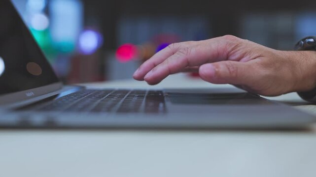 Senior employee conducts online research in modern office space, leading corporate research efforts alongside financial analysis project tasks.