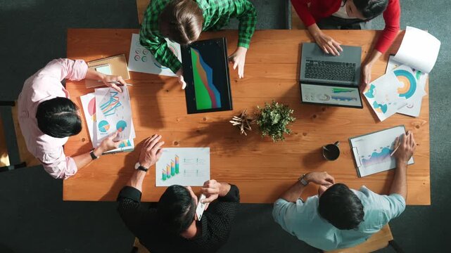 Top down view of business woman explain and present financial chart. Diverse group discuss and listen presentation about stock market statistic at meeting table with investment graph. Convocation.
