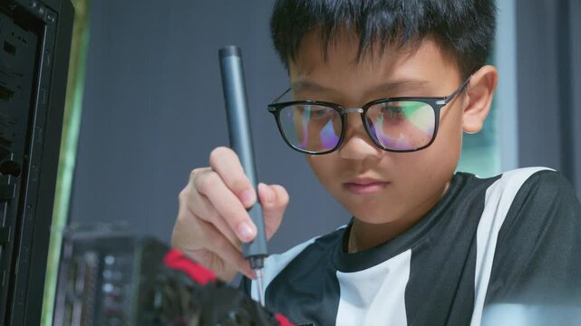 Young boy concentrating while repairing and assembling hardware inside an open desktop computer case at home, learning technology and problem solving skills