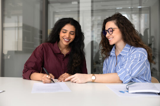 Female business consultant or advisor, guiding client through signing contract in office, customer accepting agreement put signature on legal document. Successful deal, services or insurance purchase