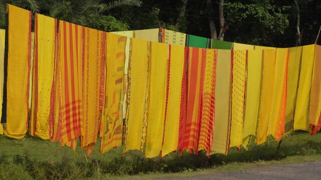 Colorful sarees hanging outdoors to dry in sunlight