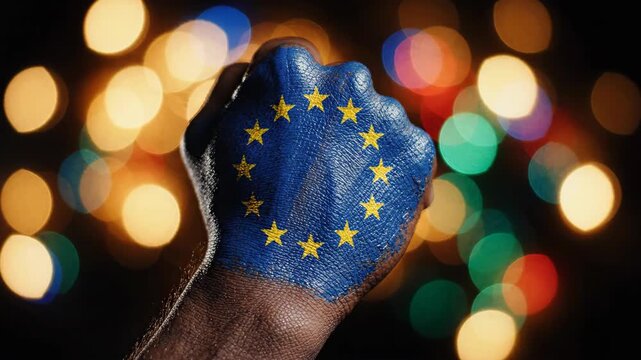 Powerful fist painted with the EU flag, symbolizing unity and strength against a bokeh background.
