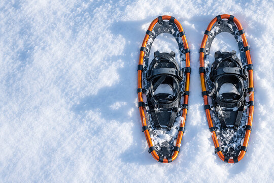 Orange Schneeschuhe auf frischem Schnee von oben