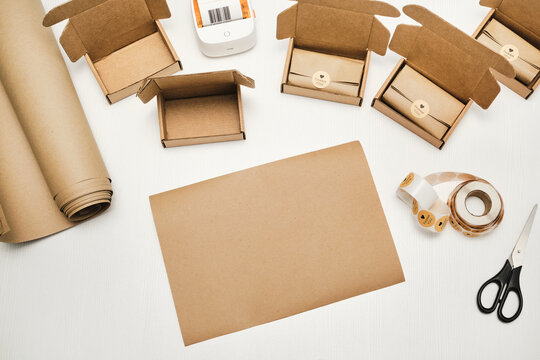 Packaging supplies and cardboard boxes with products and thank you stickers on white table