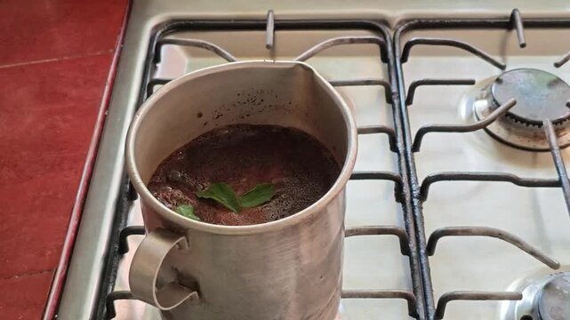 Adding Fresh Basil Leaves into Boiling Coffee Pot