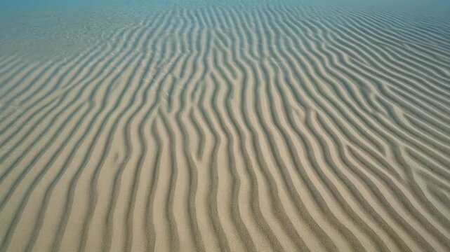 浅瀬の砂紋を越える透明な波 シームレスループ動画背景 16:9 4K