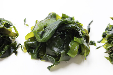 Fresh green wakame seaweed on a white background. © Bowonpat