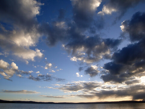 Serene Lake Scene with Cloudy Sky and Calm Water