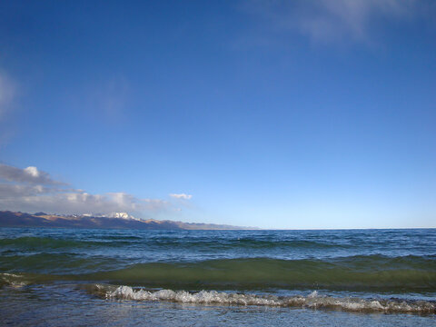 Scenic beach with clear blue water and sandy shore under bright sky