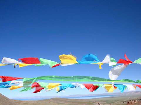 Colorful prayer flags fluttering under a clear blue sky