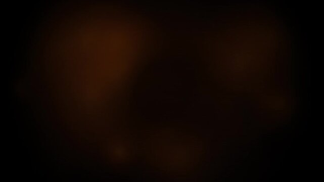 Floating golden light particles shimmering slowly in dark space for motion background.