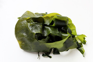 Fresh green wakame seaweed on a white background. © Bowonpat