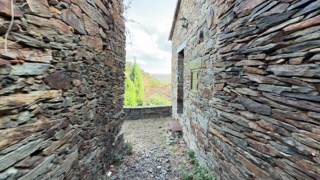 Patones first person view walking down a narrow stone alley in patones, spain