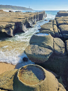 Natural rock pools and a surf-filled channel at Soldiers Point, with weathered coastal rock formations on the Central Coast of New South Wales, Australia.