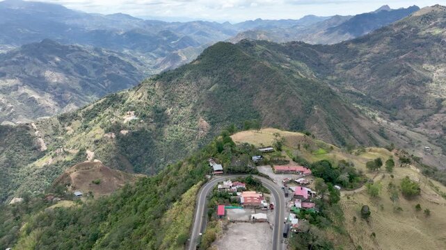 Heavy Truck Traffic on Winding Mountain Highway at Alto de La Mona in Guaduas, Colombia. Establishing Shot. Aerial View.