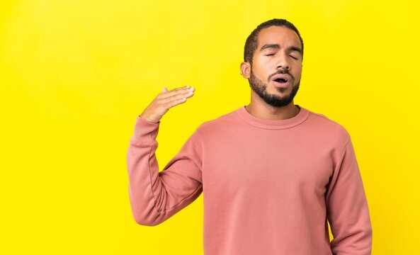 Young latin man isolated on yellow background with tired and sick expression