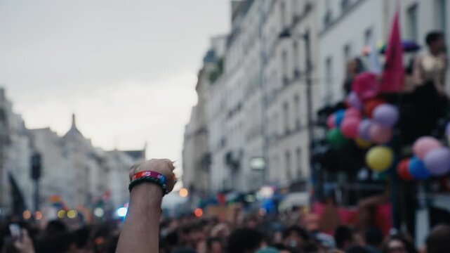 Person waving a rainbow fan at a pride parade