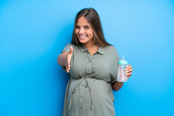 Pregnant woman on blue background shaking hands for closing a good deal © luismolinero