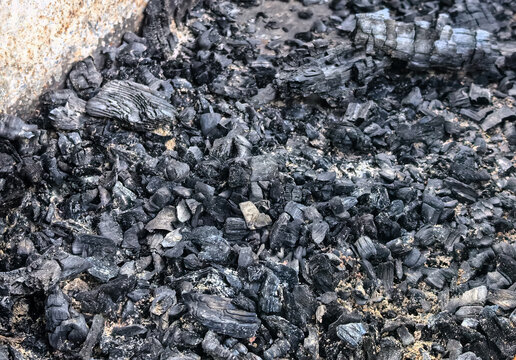 Black charcoal pieces and ash texture after burning wood fire