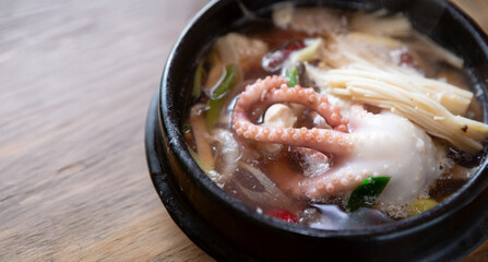 Gourmet Korean beef and octopus hot pot known as Bulnak-jeonggol with various fresh mushrooms and vegetables in a black pot © mnimage