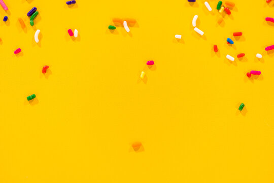 Bright yellow background with colorful sprinkles