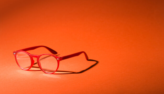 Optical Store Sale Banner Background with Red Glasses and Copy Space on Orange Surface