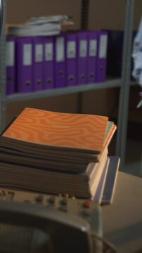 Dim office desk with folders and small fan