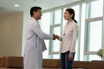 Doctor greeting patient with handshake during medical consultation in medical office in bright clinical setting during healthcare discussion © Stock Media Labs
