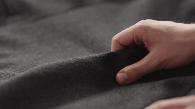 Slow motion man hands inspecting coat before season
