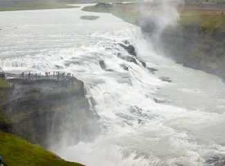 Powerful Gullfoss Waterfall Cascade and Tourists in Iceland © vadiml