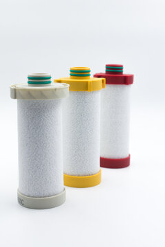 Compressed air inline filter element replacement cartridges on white background. Studio shot of three high-efficiency coalescing and particulate filter element cartridges for compressed air line syste