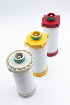 Compressed air inline filter element replacement cartridges on white background. Studio shot of three high-efficiency coalescing and particulate filter element cartridges for compressed air line syste