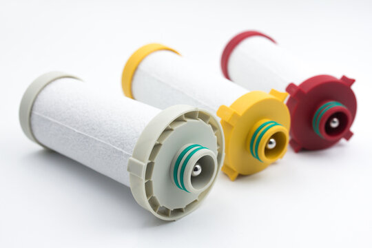Compressed air inline filter element replacement cartridges on white background. Studio shot of three high-efficiency coalescing and particulate filter element cartridges for compressed air line syste