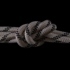 Braided rope knot against a black background © Damien