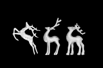 Silver Christmas Eve reindeer tree decorations on black background. Traditional ornaments for the festive holiday season.  © marilyn barbone