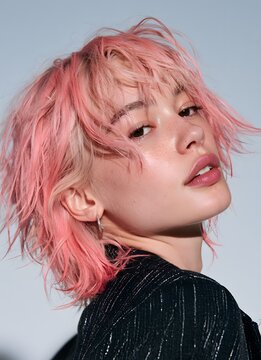 Nahaufnahme-Portr&auml;t einer stilvollen jungen Person mit rosa Haaren und Fransenschnitt, ideal f&uuml;r Mode-Magazine, Sch&ouml;nheitssalons und Trend-Editorial