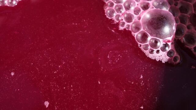 Bubbles on a red wine. Natural fermentation of the wort. Alcohol background. Minimal. Copy space.