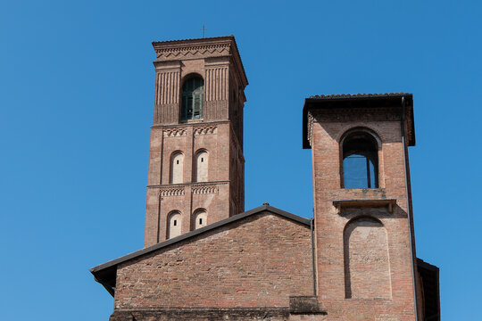 Bologna, Italy, August 5, 2026. A low angle view of the historic red brick bell towers and roofline of the Basilica of San Giacomo Maggiore against a clear blue sky in Bologna Italy