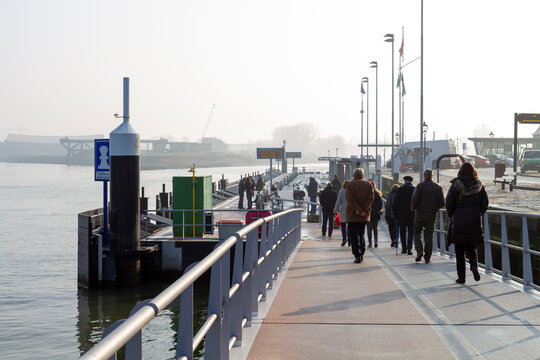A busy river ferry terminal in soft morning haze during rush hour. Ideal for travel, transportation, tourism, and waterfront infrastructure concepts.